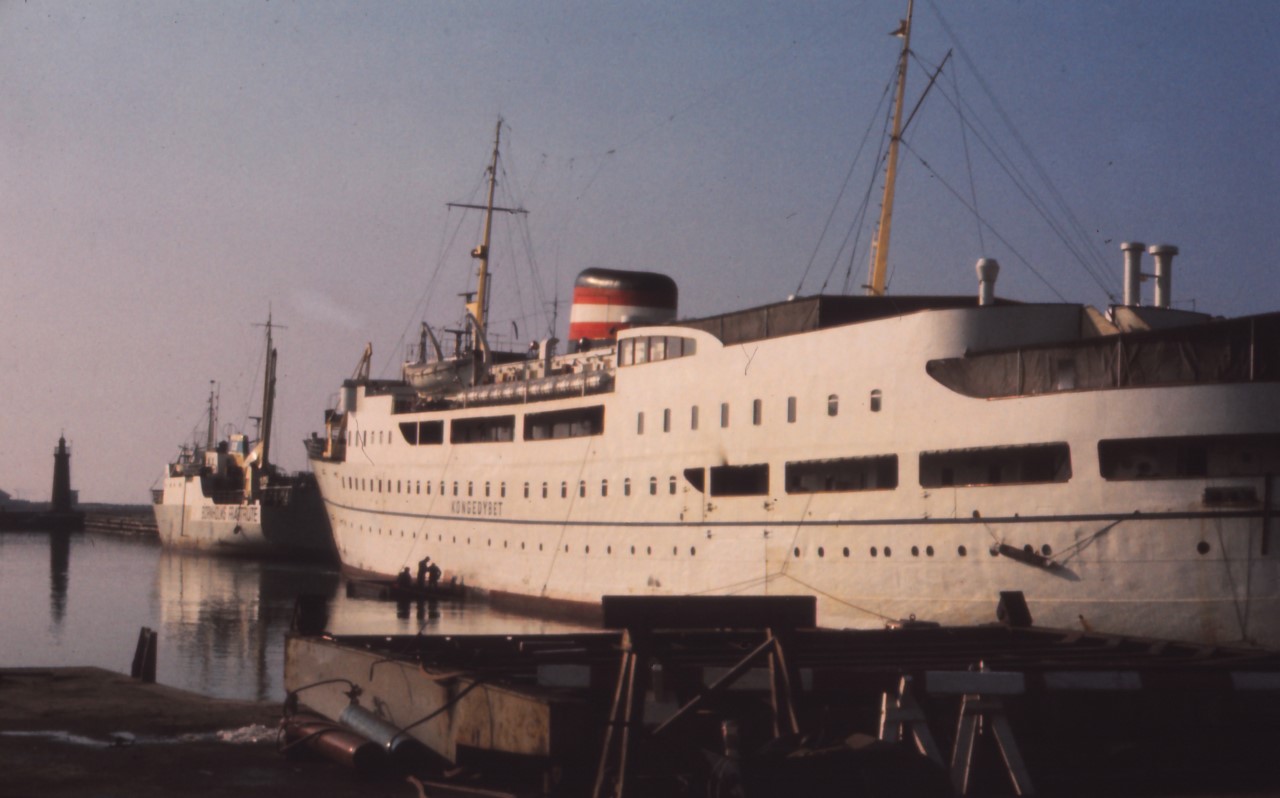 Januar 2023: Rønne havn i foråret 1976, ved kajen ligger Bornholmstrafikkens skibe 66-PAKETTEN og KONGEDYBET. 66-PAKETTEN blev solgt til Norge i 1980, mens KONGEDYBET blev solgt til Kina i 1979 og ophugget i 1996. Foto: Lasse Micheelsen
